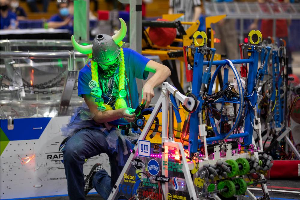 A team member works on a robot on the field